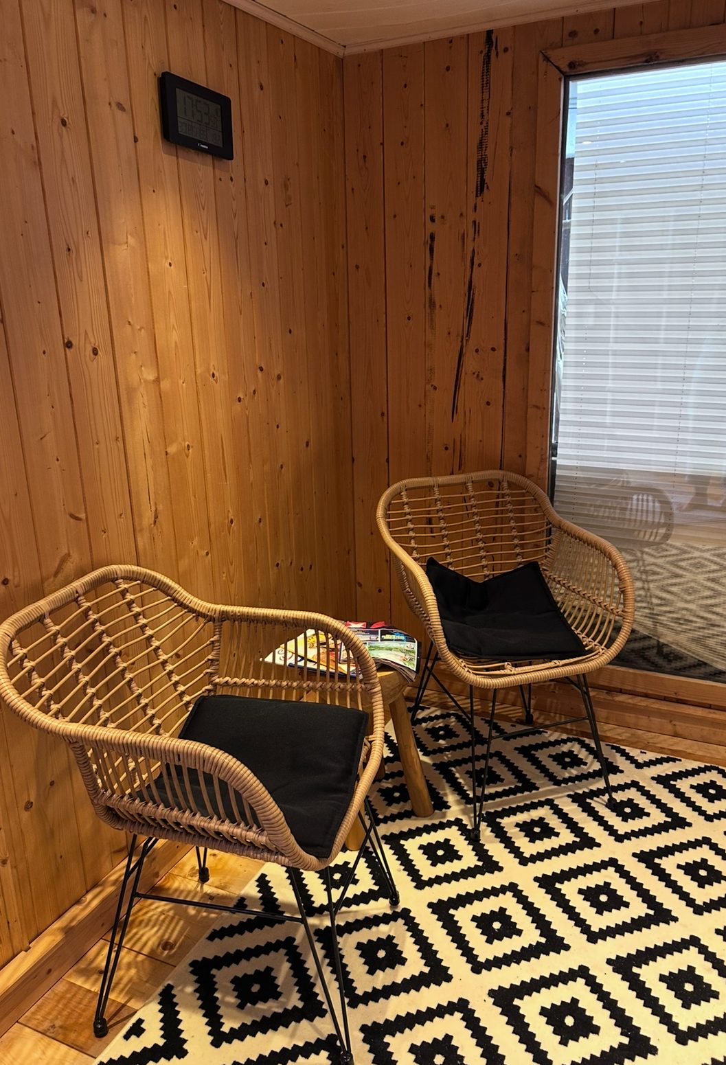 Holzsauna mit Sitzbank, moderner Fußboden und dekorativer Teppich im Innenraum.